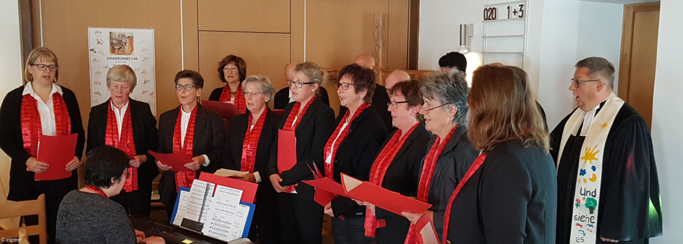 Kirchenchor bei einem Auftritt in dunkler Kleidung mit rotem Schal