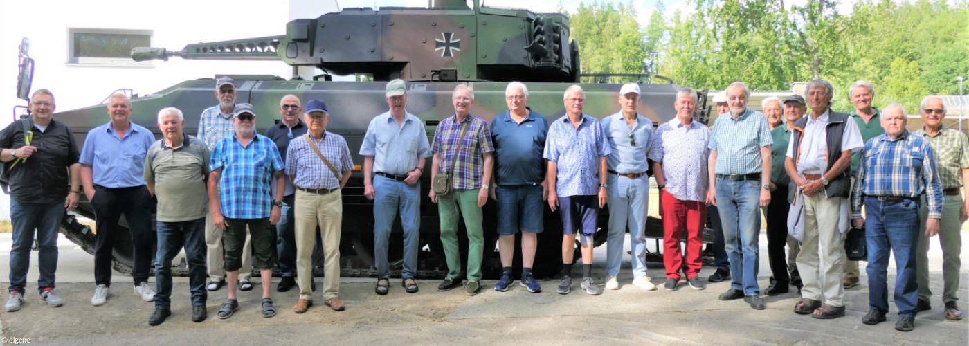 Männer stehen vor einem Panzer aufgereiht bei Besichtigung