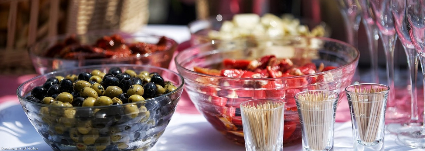 Gläser und Schüsseln mit Tapas und Zahnstocher davor