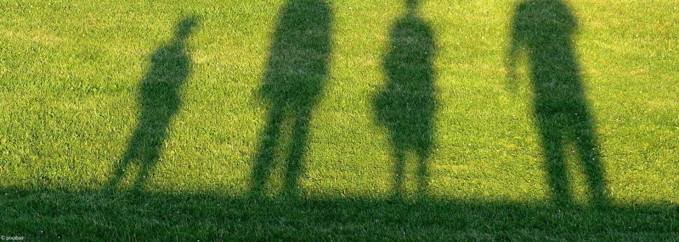 Schatten von 4 Menschen im Rasen
