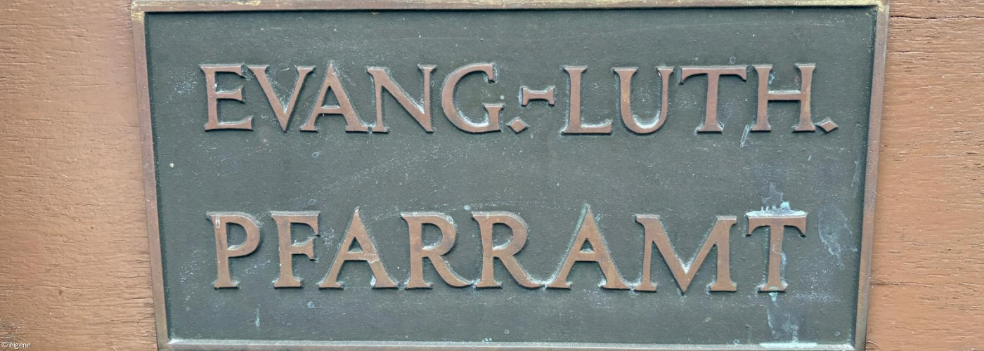 Türschild mit Aufschrift Evang.-Luth. Pfarramt