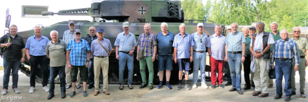 Männer stehen vor einem Panzer aufgereiht bei Besichtigung