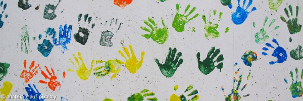 bunte Handabdrücke von Kindern auf weißer Wand