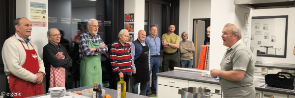 Der Chefkoch erklärt den Lehrlingen den Ablauf