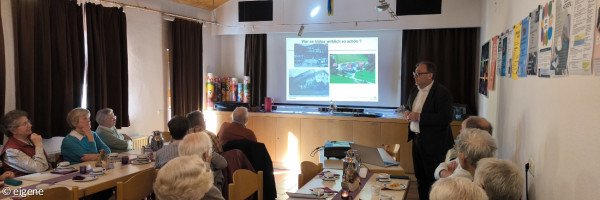 Foto vom Kaffeenachmittag: ältere Menschen folgen einem Vortrag im Gemeinderaum