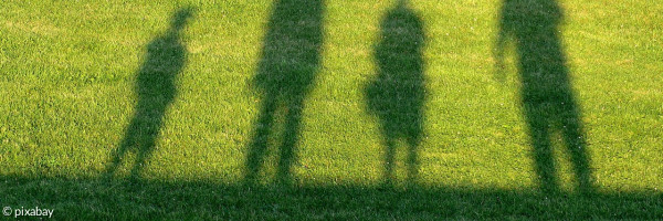 Schatten von 4 Menschen im Rasen
