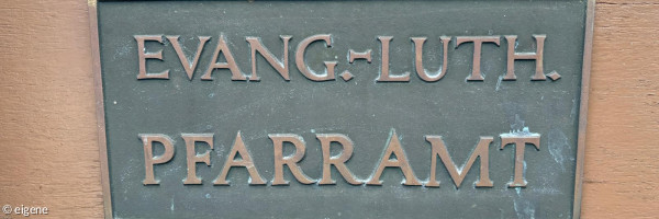 Türschild mit Aufschrift Evang.-Luth. Pfarramt