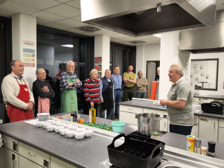 Der Chefkoch erklärt den Lehrlingen den Ablauf