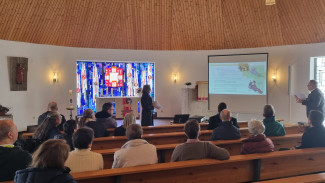 Zuhörer in der St. Johanneskirche folgen dem Vortrag von Pfr. Schricker und Ch.Lorenz